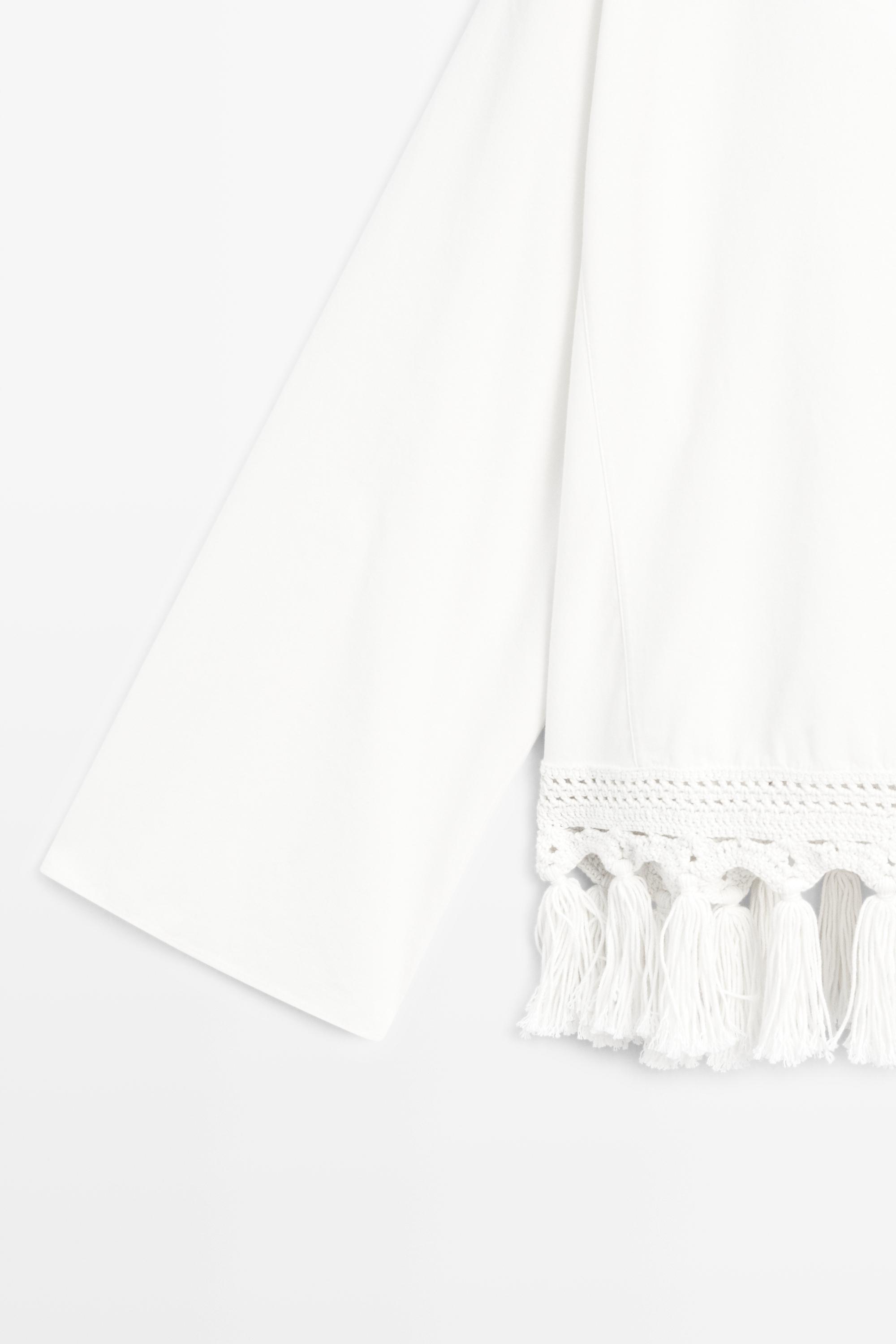Embroidered blouse with fringed hem